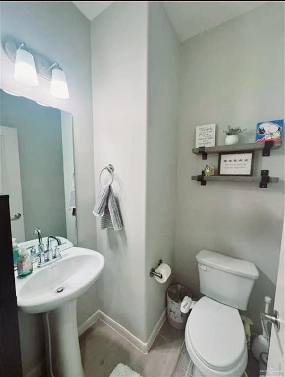 bathroom with toilet and baseboards