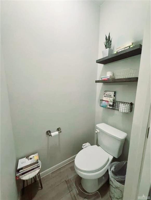 bathroom featuring toilet and baseboards