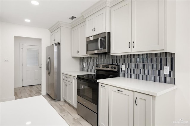 321 E Stubbs St, Edinburg, TX 78539 - kitchen with stainless steel appliances, light countertops, white cabinets, backsplash, and recessed lighting
