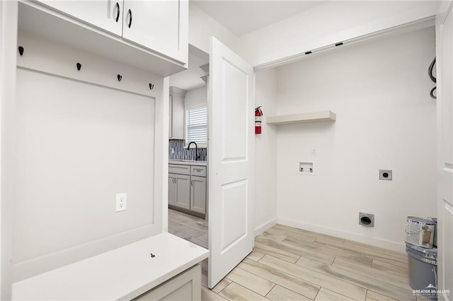 321 E Stubbs St, Edinburg, TX 78539 - laundry room with hookup for an electric dryer, cabinet space, hookup for a washing machine, and light wood-style flooring