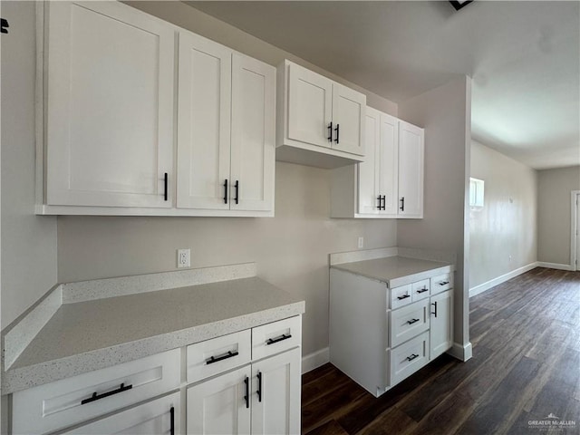 kitchen with light countertops, baseboards, and dark wood finished floors