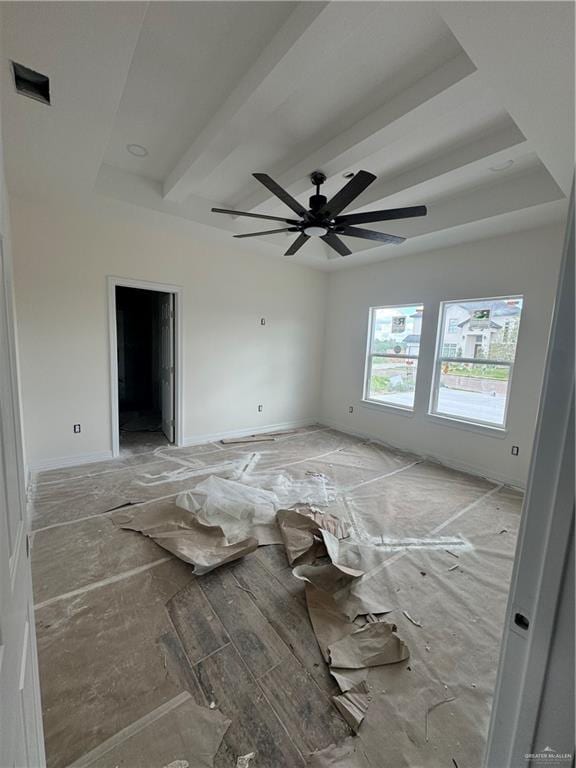 unfurnished room featuring beamed ceiling and ceiling fan