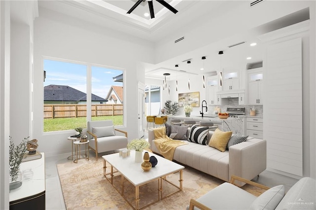 living room featuring ceiling fan, sink, and a high ceiling