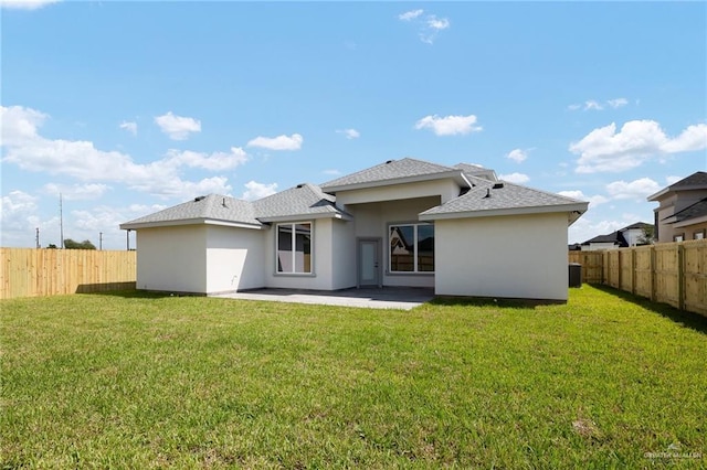 back of house featuring a lawn and a patio