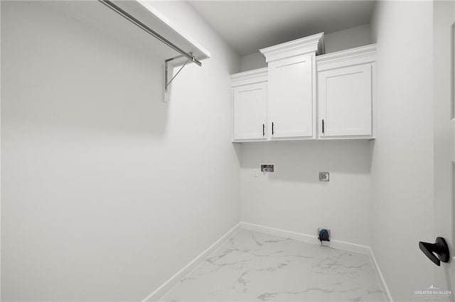 clothes washing area with hookup for an electric dryer, washer hookup, and cabinets