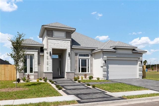 prairie-style home featuring a garage and a front lawn