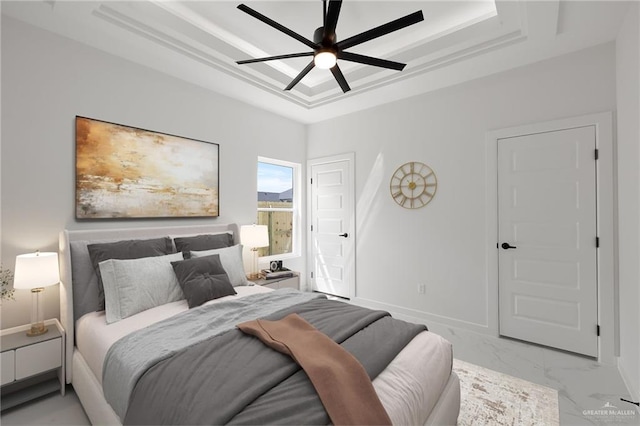 bedroom featuring a raised ceiling and ceiling fan