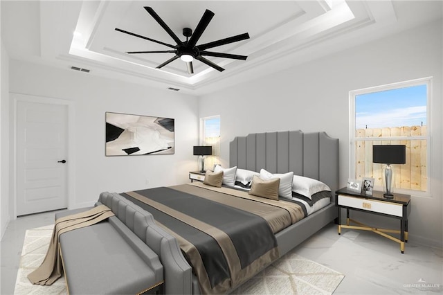 bedroom featuring ceiling fan and a raised ceiling