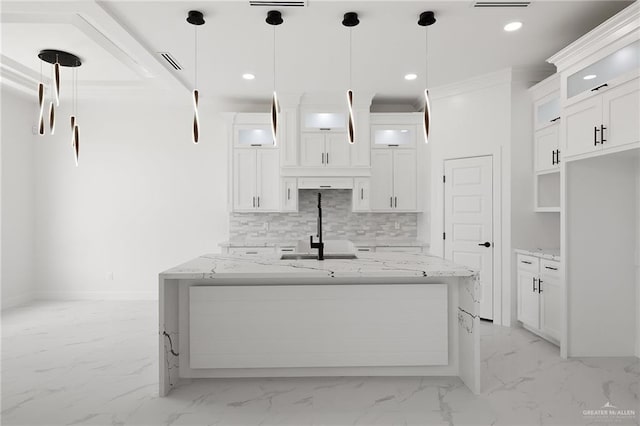 kitchen with light stone countertops, decorative light fixtures, and white cabinetry