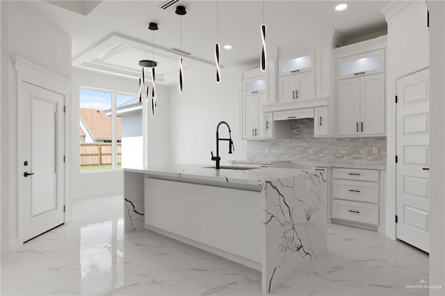 kitchen with backsplash, sink, white cabinets, and pendant lighting