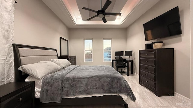 bedroom with a raised ceiling and ceiling fan