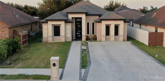 view of front of home featuring a lawn and cooling unit