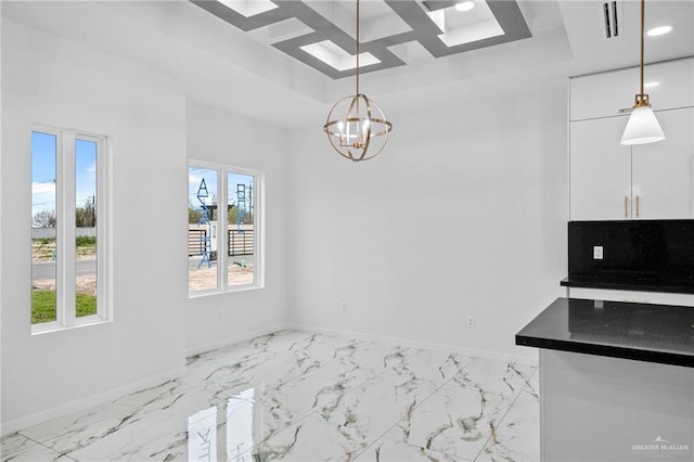 unfurnished dining area featuring marble finish floor, a chandelier, baseboards, and a raised ceiling