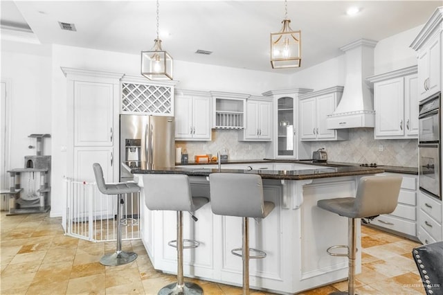 kitchen featuring a kitchen breakfast bar, a center island, premium range hood, and hanging light fixtures