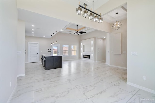 2400 Windmill Palm, Rio Grande City, TX 78582 - unfurnished living room with a sink, baseboards, coffered ceiling, beamed ceiling, and marble finish floor