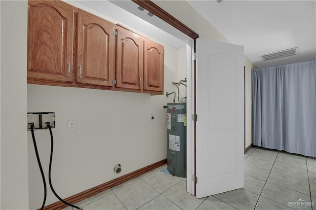 laundry room featuring cabinets, hookup for an electric dryer, electric water heater, hookup for a washing machine, and light tile patterned flooring