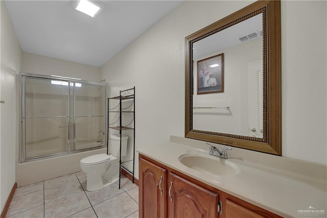 full bathroom featuring tile patterned floors, vanity, toilet, and shower / bath combination with glass door