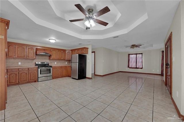 kitchen with appliances with stainless steel finishes, tasteful backsplash, a raised ceiling, ceiling fan, and light tile patterned floors