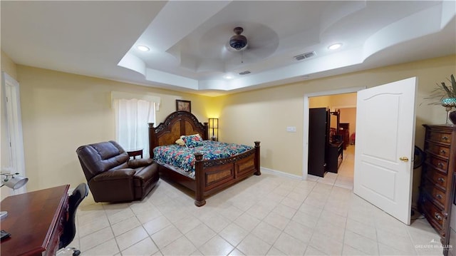 tiled bedroom with a raised ceiling and ceiling fan