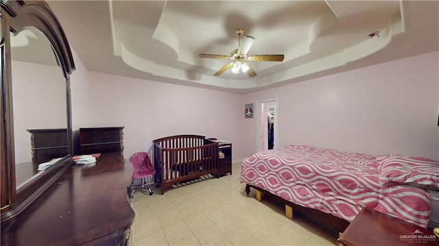 bedroom with a tray ceiling and ceiling fan