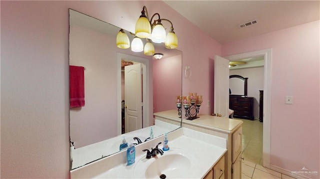 bathroom with tile patterned flooring, a notable chandelier, and vanity