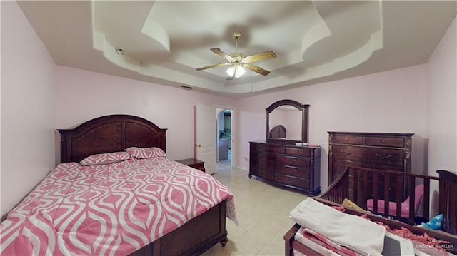 bedroom with a raised ceiling and ceiling fan