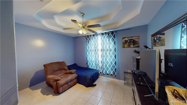 tiled bedroom featuring ceiling fan and a raised ceiling