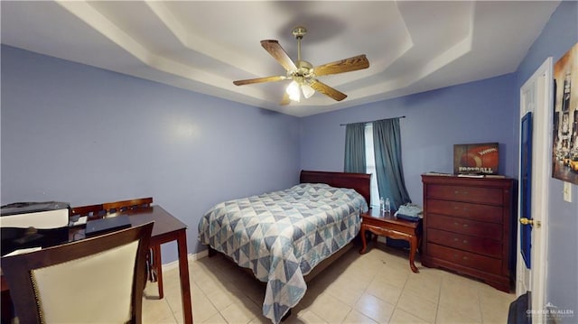 tiled bedroom featuring a tray ceiling and ceiling fan