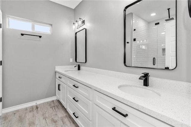 bathroom featuring hardwood / wood-style floors, vanity, and a shower with shower door