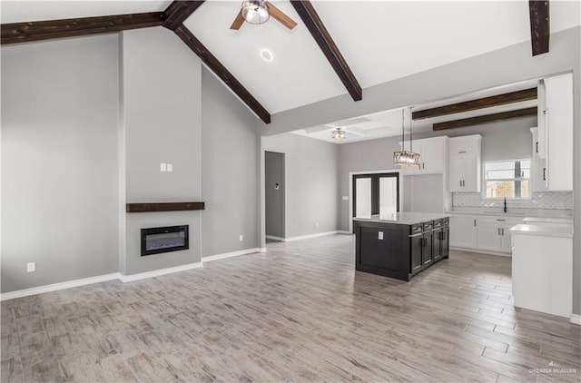 kitchen featuring white cabinetry, a center island, hanging light fixtures, and light wood-type flooring