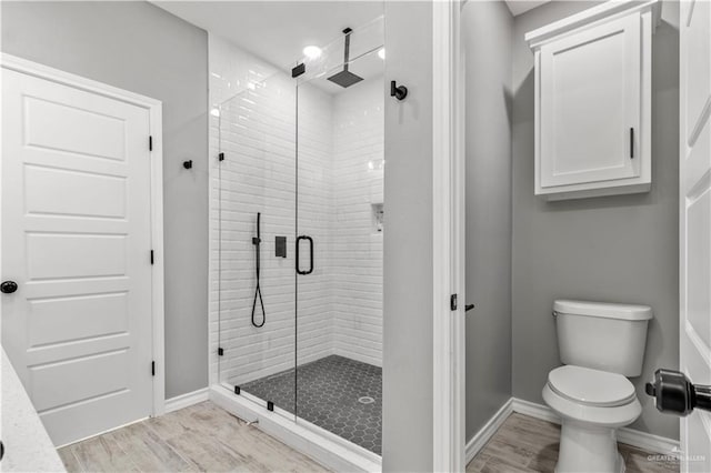 bathroom featuring hardwood / wood-style floors, an enclosed shower, and toilet