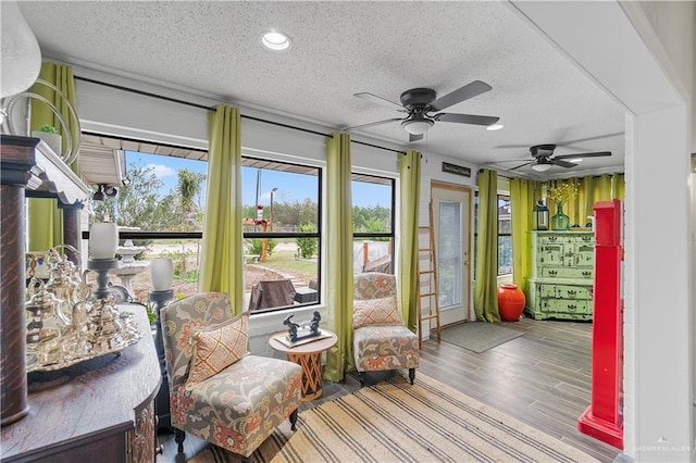 sunroom / solarium featuring plenty of natural light and ceiling fan