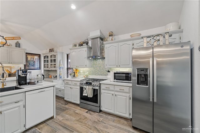 kitchen with sink, white cabinets, stainless steel appliances, and vaulted ceiling