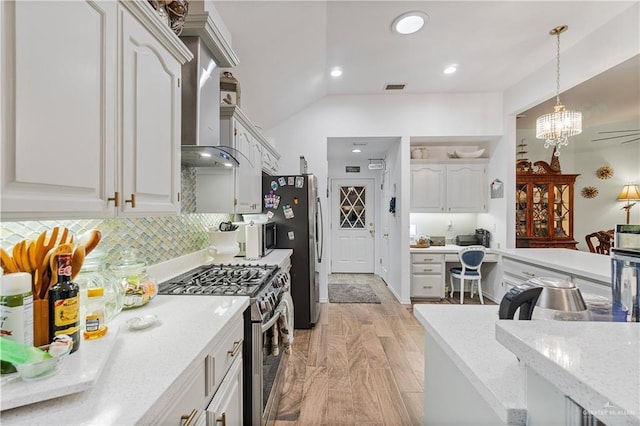 kitchen with white cabinets, hanging light fixtures, decorative backsplash, wall chimney exhaust hood, and stainless steel appliances