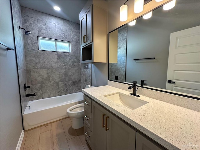 bathroom featuring baseboards, toilet, wood finished floors,  shower combination, and vanity