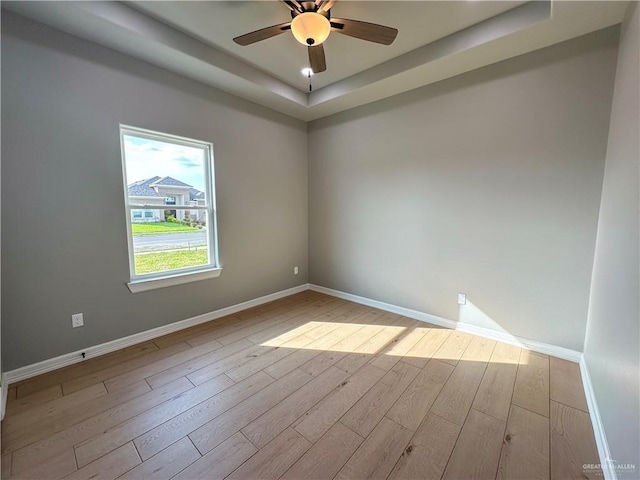 spare room with ceiling fan, baseboards, and wood finished floors