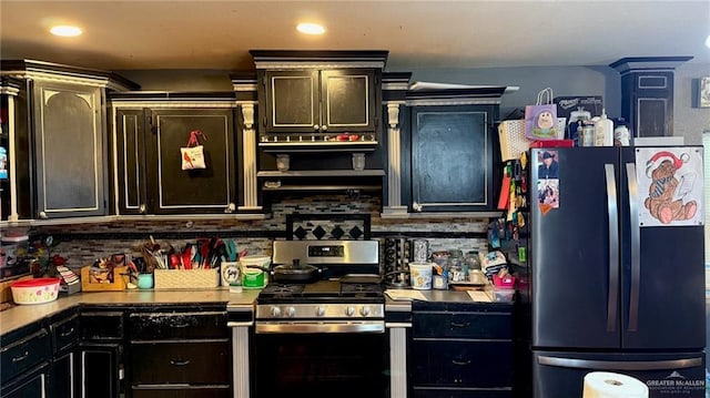 kitchen featuring stainless steel gas range, fridge, and tasteful backsplash