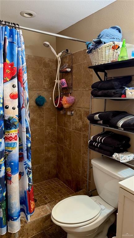 bathroom with toilet and a shower with shower curtain