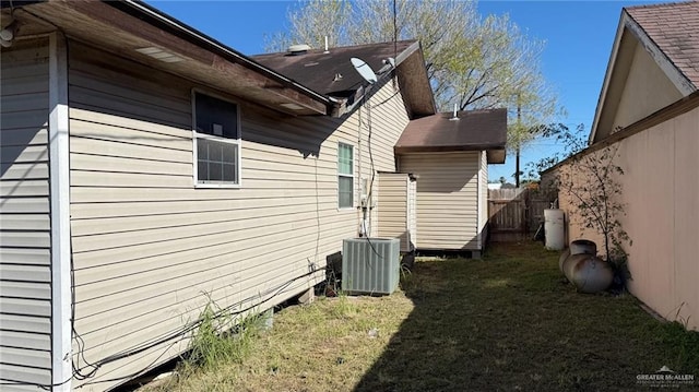 view of side of home with a yard and central air condition unit