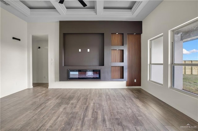 unfurnished living room with ceiling fan, a large fireplace, beamed ceiling, and coffered ceiling