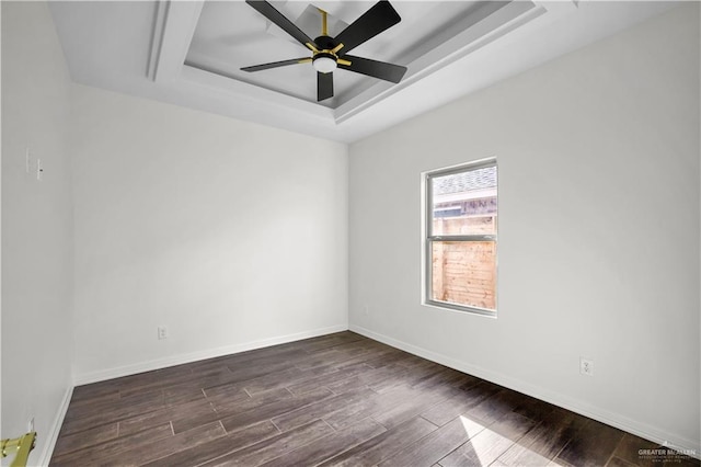 empty room with a raised ceiling and ceiling fan