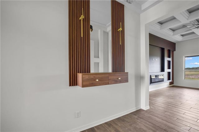 corridor with beamed ceiling, a chandelier, coffered ceiling, and hardwood / wood-style flooring