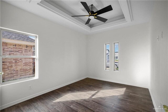 spare room with a tray ceiling and ceiling fan