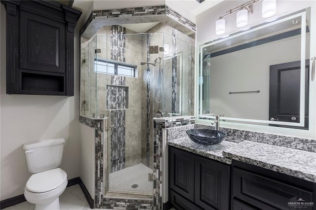 bathroom featuring vanity, a shower with shower door, and toilet