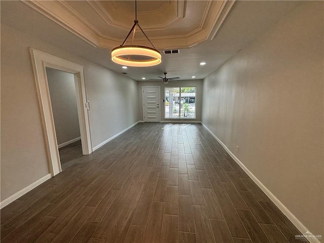 unfurnished room with ceiling fan, a raised ceiling, dark wood-type flooring, and crown molding