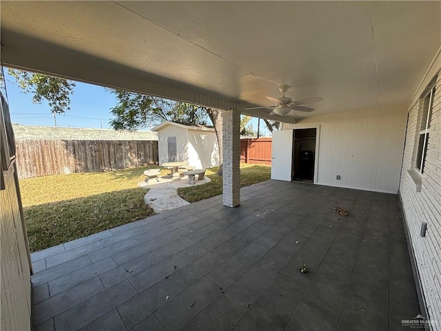 view of patio / terrace featuring ceiling fan and an outbuilding