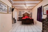 tiled bedroom featuring beamed ceiling