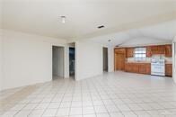 spare room with light tile patterned floors and vaulted ceiling