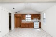 kitchen featuring white range oven and vaulted ceiling