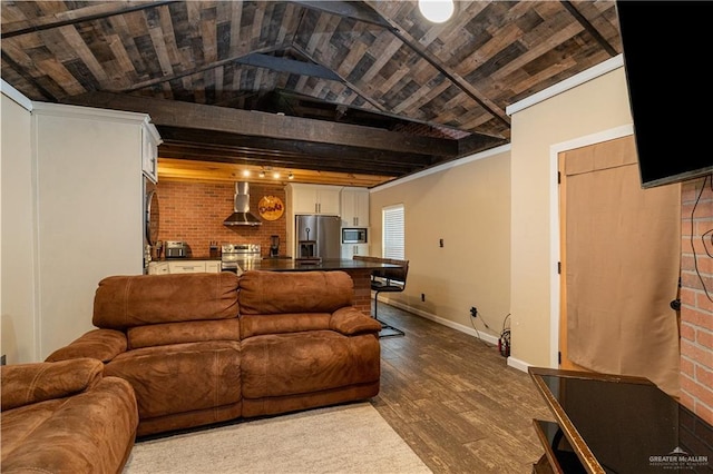 living area featuring lofted ceiling, baseboards, dark wood finished floors, and brick wall